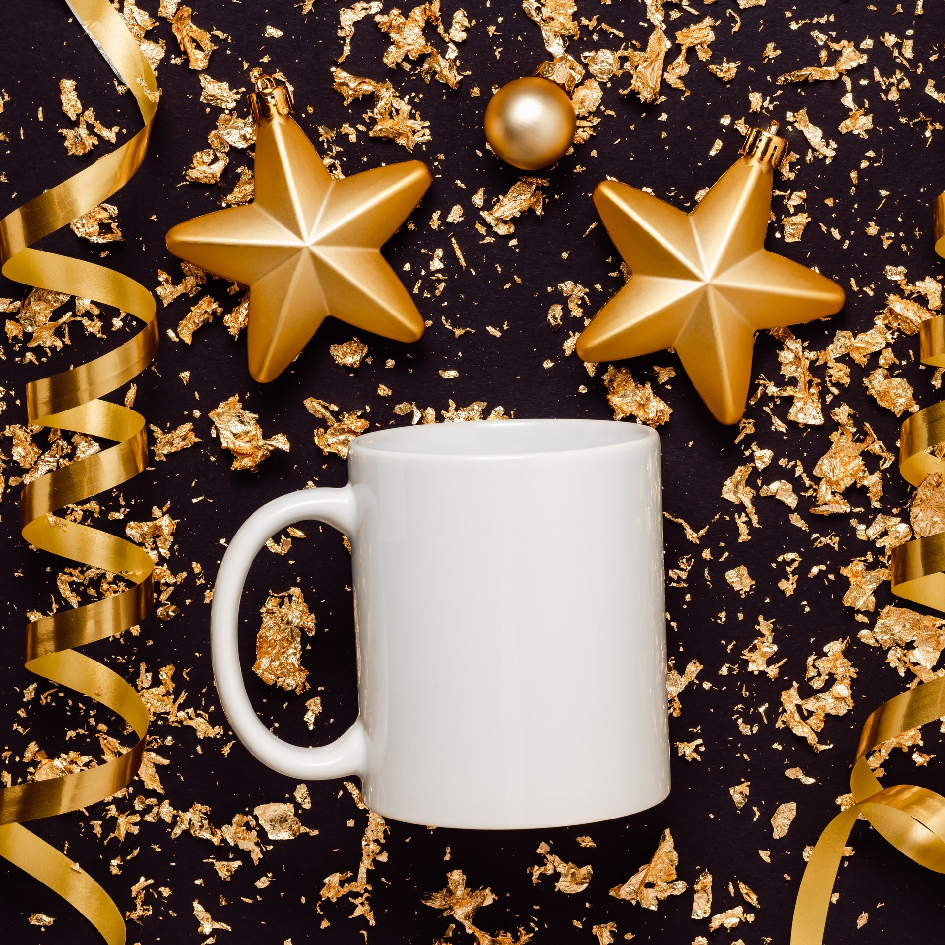 White mockup mug with christmas toys, golden ribbons on black glittering background